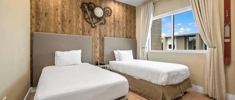 Une chambre d’hôtel avec deux lits, des murs lambrissés, une horloge et une fenêtre avec des rideaux.