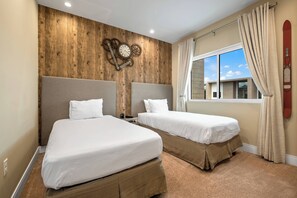 A hotel room with two beds, wooden panel walls, a clock, and a window with curtains. - Mvv7485 - 3BR House Near Disney With Hot Tub (Kissimmee)