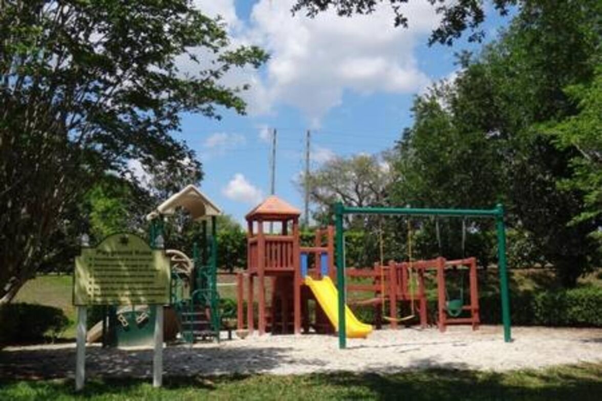Ein Spielplatz mit Rutsche, Klettergerüsten und einem kleinen Turm.