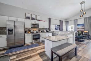 A modern kitchen with stainless steel appliances, granite countertops, and a central island. - Hl137 - 5BR House With Pool Near Disney Area (Davenport)