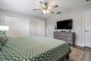 A bedroom with a bed, a ceiling fan, a dresser, and a TV. - Pp8962 - 4BR House With Pool Near Disney Parks (Kissimmee)