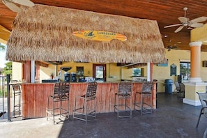A bar area with a thatched roof, bar stools, and a sign reading "LANDSHARK". - Pp8962 - 4BR House With Pool Near Disney Parks (Kissimmee)