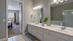 Un bany modern amb un gran lavabo, un mirall i una zona de dutxa.