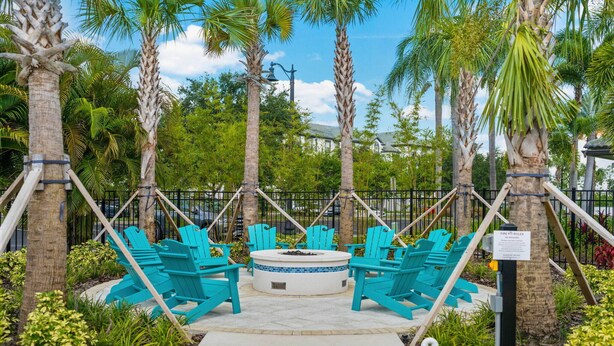 A fire pit area with turquoise Adirondack chairs and a circular seating arrangement. - Vc11-405 - 3BR Condo With Resort Access in Orlando (Orlando)