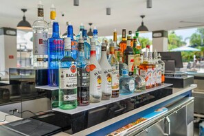 Eine Bar mit einer Auswahl an Spirituosenflaschen, die in Regalen präsentiert werden.