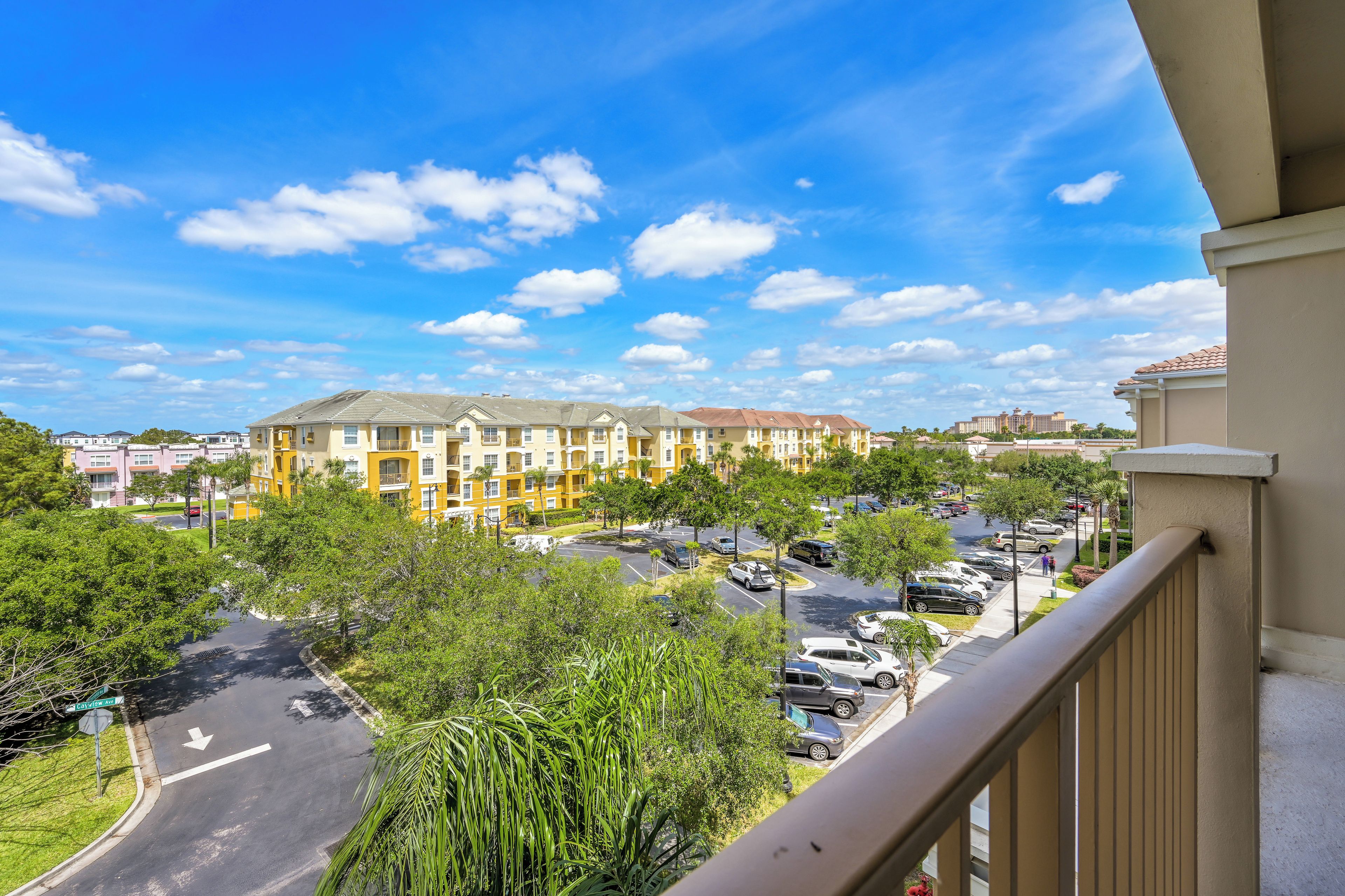 A residential area with a yellow building, a parking lot, and a clear sky.