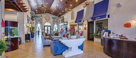 A spacious lobby with a reception desk, seating area, and a large fish tank.