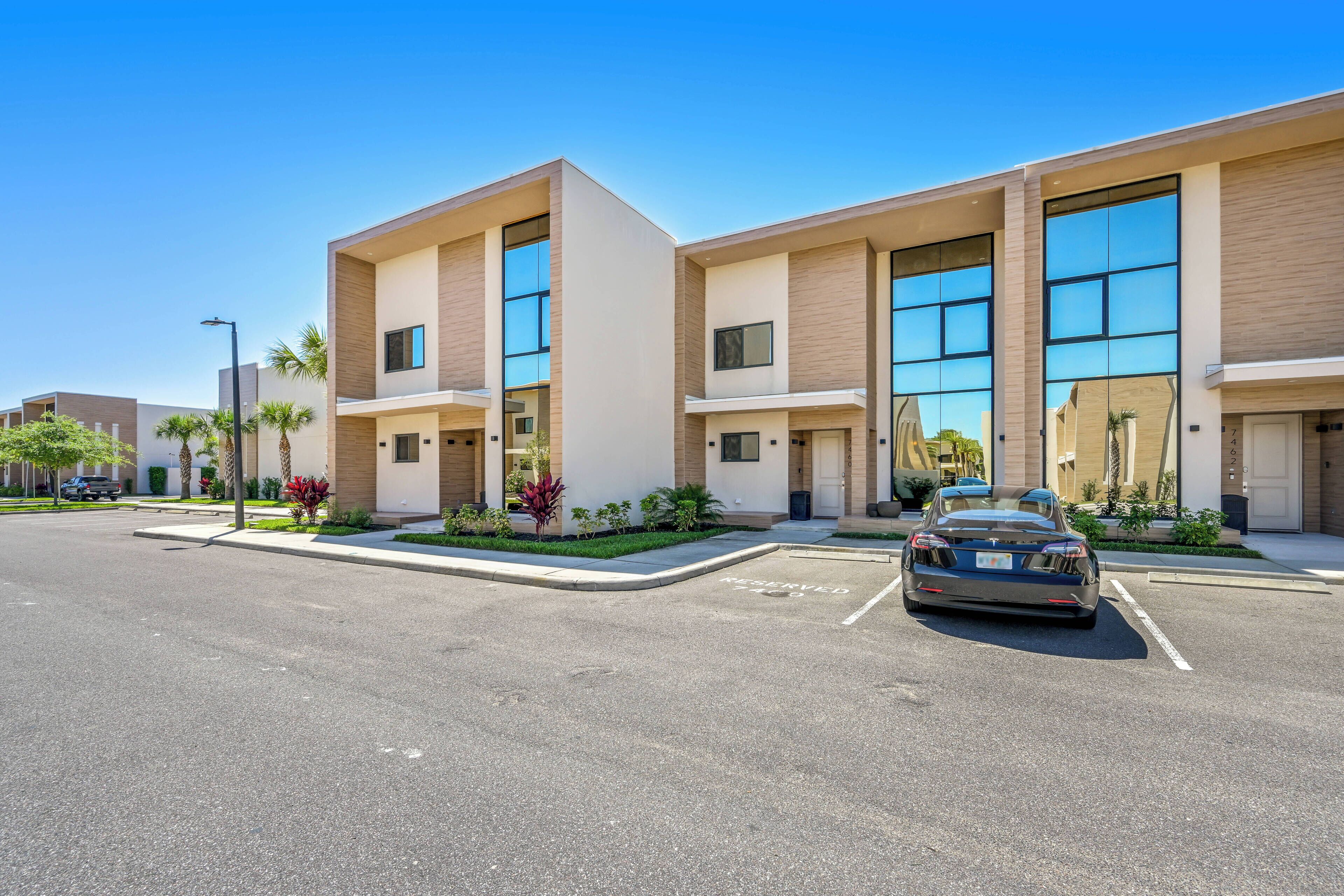 A modern building with large windows and a parking lot.