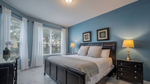 A bedroom with a bed, two bedside tables, a dresser, and a window with curtains. - Wh2545 - 5BR House Resort Access Near Disney Parks (Kissimmee)