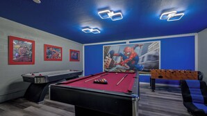A pool table with a red felt surface, a foosball table, and two framed posters on the wall. - Wh2545 - 5BR House Resort Access Near Disney Parks (Kissimmee)