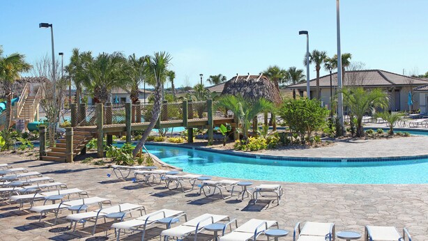 A pool area with lounge chairs and a wooden deck. - Cg9025 - 5BR House With Pool Near Disney (Davenport)