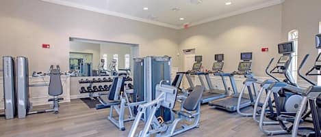 A gym with various exercise machines, treadmills, and weights.