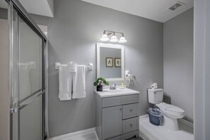 A bathroom with a shower, a sink with a mirror, and a toilet. - Th20 - 3BR House With Resort Access Near Parks (Orlando)
