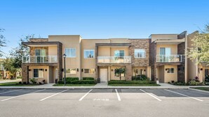 A multi-story residential building with a parking lot in front. - Mvy7632 - 4BR House Near Disney (Kissimmee)