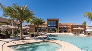 A hotel pool area with a hot tub, lounge chairs, and palm trees. - Mvy7632 - 4BR House Near Disney (Kissimmee)