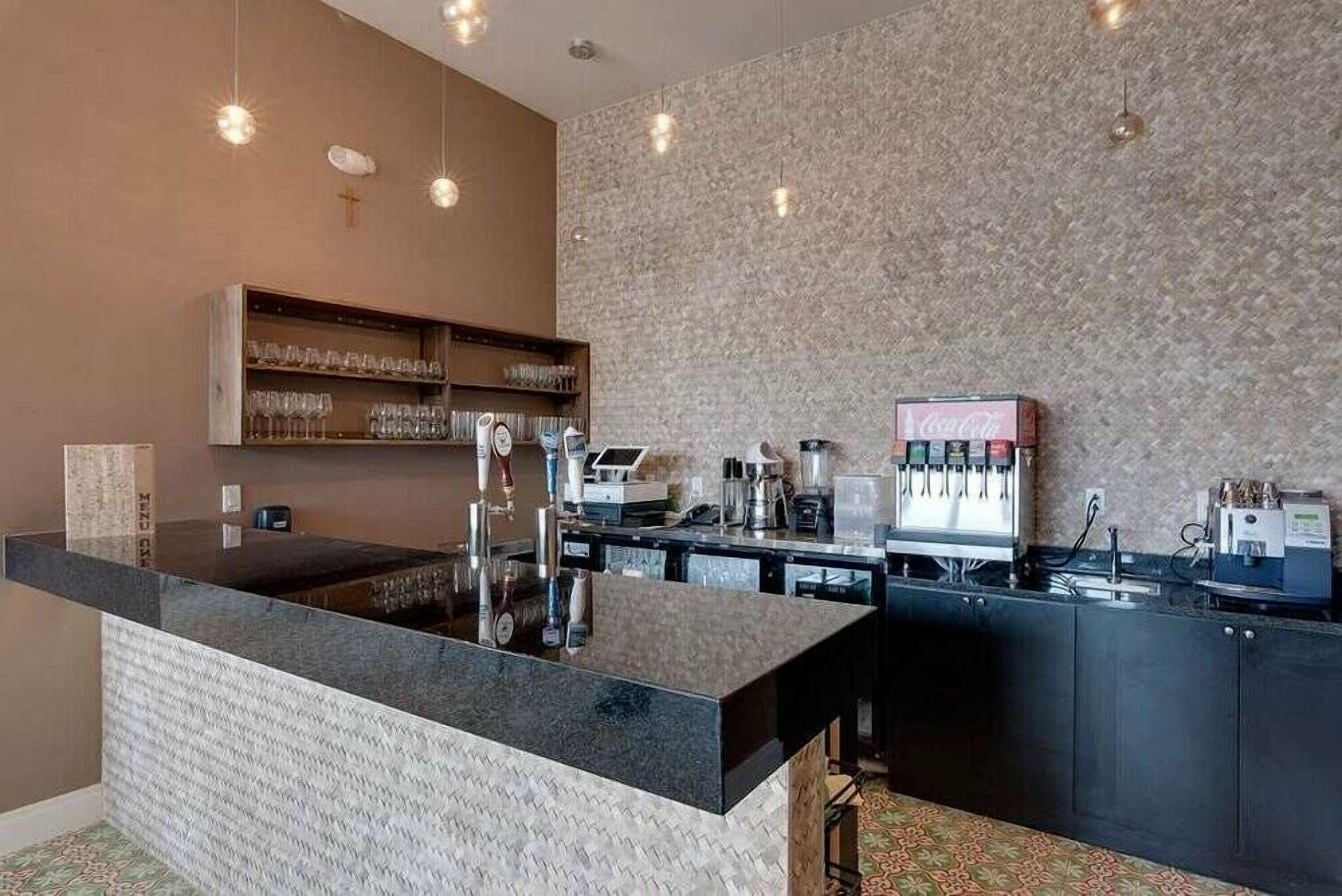 Een moderne keuken met een centraal eiland, inbouwapparatuur en een Coca-Cola koelkast.