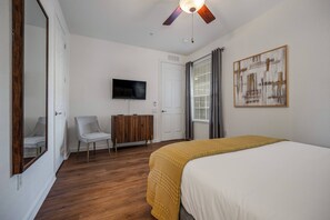 A bedroom with a bed, a television, a wardrobe, a chair, and a ceiling fan. - Vc6-105 - 3BR Condo Resort Access Near Disney (Orlando)