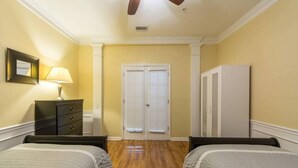 A bedroom with two beds, a dresser, a lamp, a wardrobe, and a door with blinds. - Vc6-105 - 3BR Condo Resort Access Near Disney (Orlando)