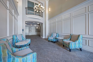 A spacious lobby with a high ceiling, a chandelier, and a view of a second-floor balcony. - Vc6-105 - 3BR Condo Resort Access Near Disney (Orlando)