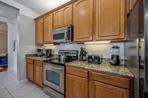 Eine Küche mit Holzsäulen, einem Edelstahlherd, einer Mikrowelle, einem Toaster und einem Mixer.
