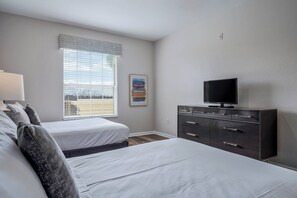 A bedroom with two beds, a dresser, a television, and a window with blinds. - Vc12-206 - 3BR Condo Lake View Near Disney (Orlando)