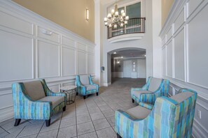 A spacious lobby with a high ceiling, a chandelier, and a balcony with a railing. - Vc12-206 - 3BR Condo Lake View Near Disney (Orlando)