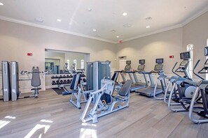 Une salle de sport équipée de divers appareils d’exercice, de tapis de course et de poids.