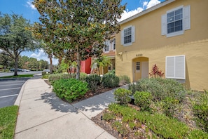 A yellow building with a number 8559, surrounded by greenery and a sidewalk. - Ei8555 - 3BR House Near Disney (Kissimmee)