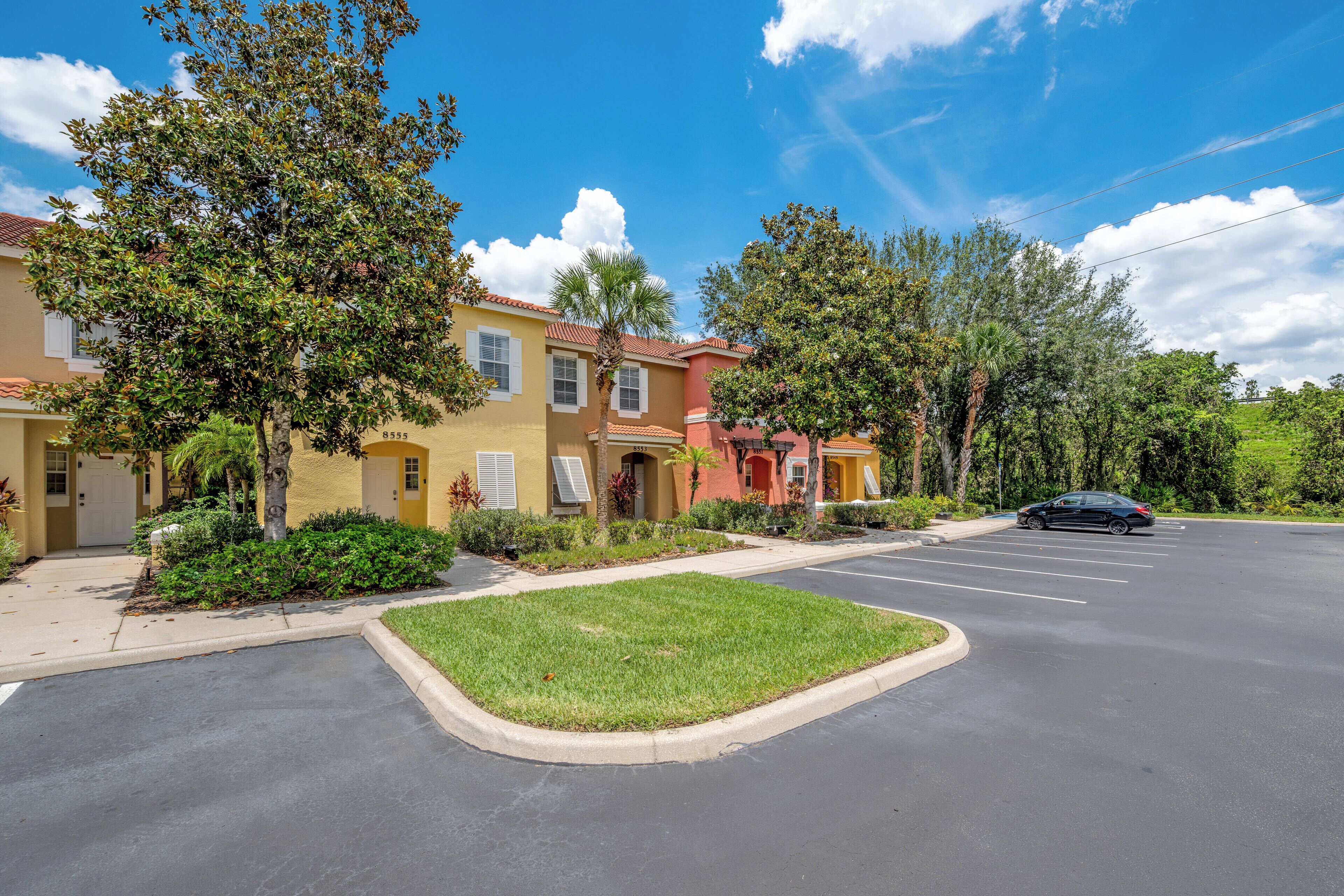 A residential street with houses, a parking lot, and a car.