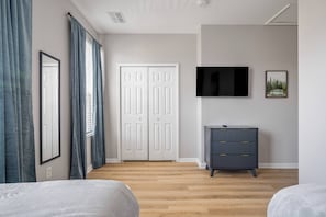 A bedroom with a bed, a dresser, a TV, and a closet. - Th14 - 3BR House With Pool Access Near Disney (Orlando)
