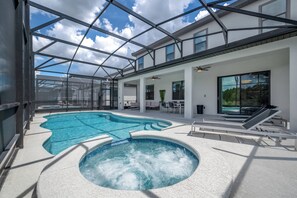 Ein moderner Poolbereich im Innenbereich mit Whirlpool, Glasdach und Sitzbereichen.