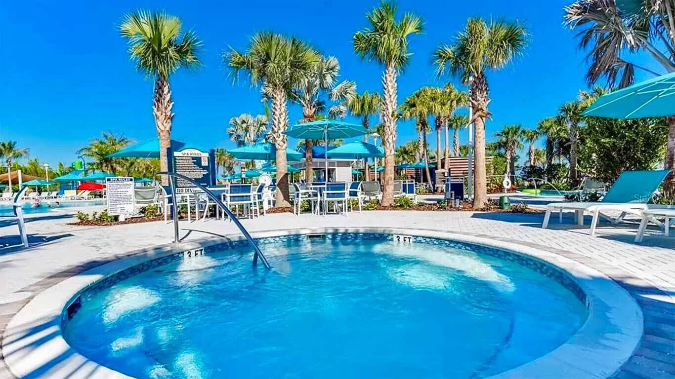 Ein Swimmingpool mit Palmen und Liegestühlen.