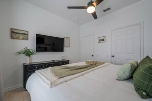 A bedroom with a bed, a television, a dresser, and a ceiling fan. - Wp304 - 2BR Fully Renovated Condo - Windsor Palms (Kissimmee)