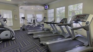 A gym with treadmills, elliptical machines, and a stationary bike. - Wp304 - 2BR Fully Renovated Condo - Windsor Palms (Kissimmee)