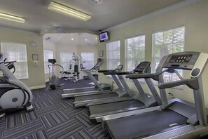 A gym with treadmills, elliptical machines, and a stationary bike. - Wp304 - 2BR Fully Renovated Condo - Windsor Palms (Kissimmee)