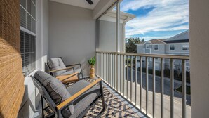 A balcony with a ceiling fan, a sofa, and a small table with a plant. - Wp304 - 2BR Fully Renovated Condo - Windsor Palms (Kissimmee)