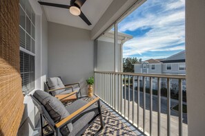 A balcony with a ceiling fan, a sofa, and a small table with a plant. - Wp304 - 2BR Fully Renovated Condo - Windsor Palms (Kissimmee)