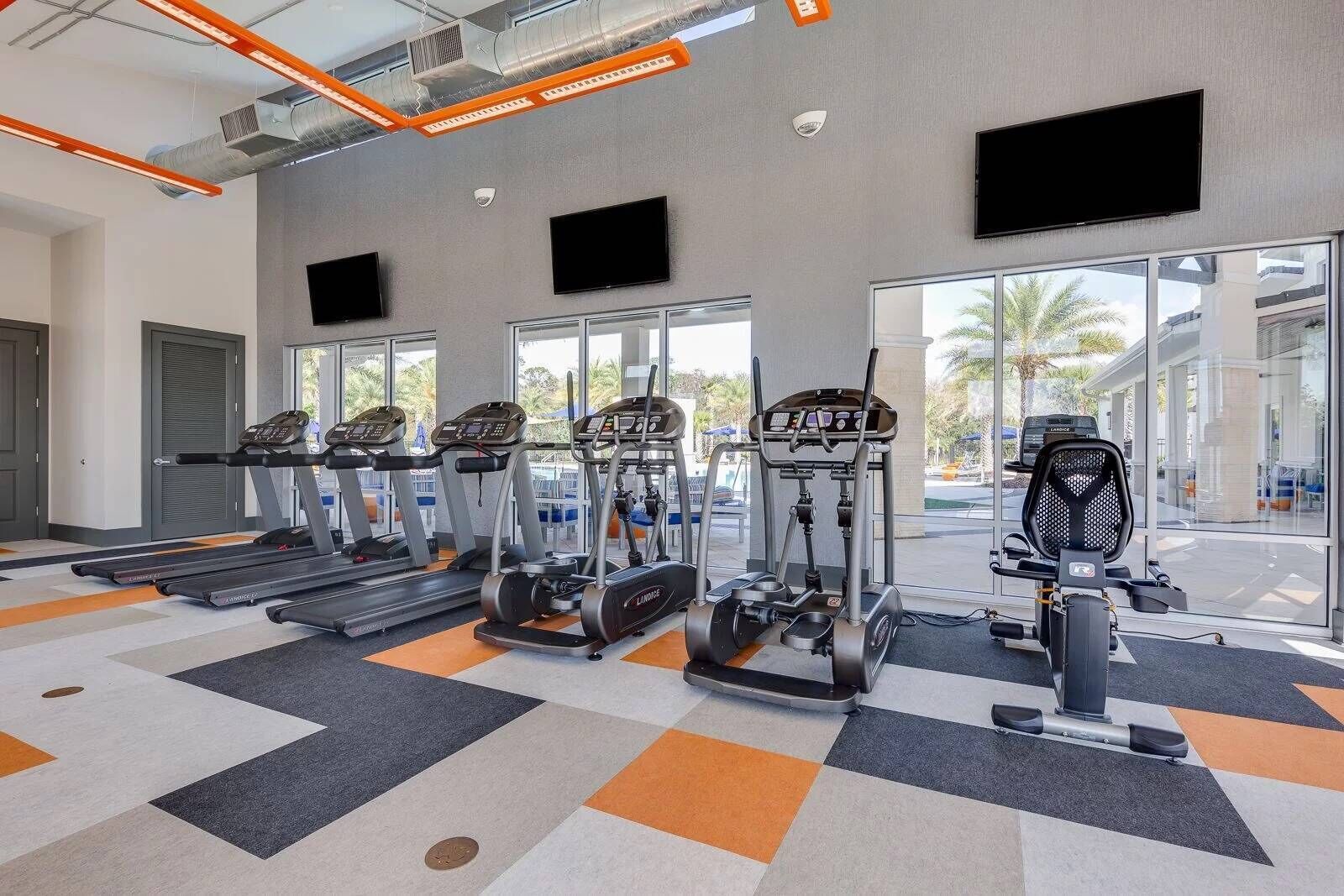 A gym with treadmills, ellipticals, and a stationary bike.