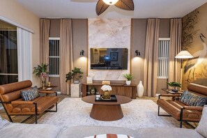 Una sala de estar moderna con sofás de cuero, una mesa de centro y un televisor de pantalla plana grande.