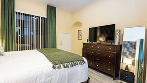 A bedroom with a bed, a dresser, a television, and a mirror. - Tu220 - 5BR House With Pool Near Disney Area (Davenport)