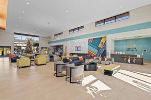 Eine großzügige Lobby mit moderner Einrichtung, einem Weihnachtsbaum und einem Schild für den Aquarius Clubhouse.