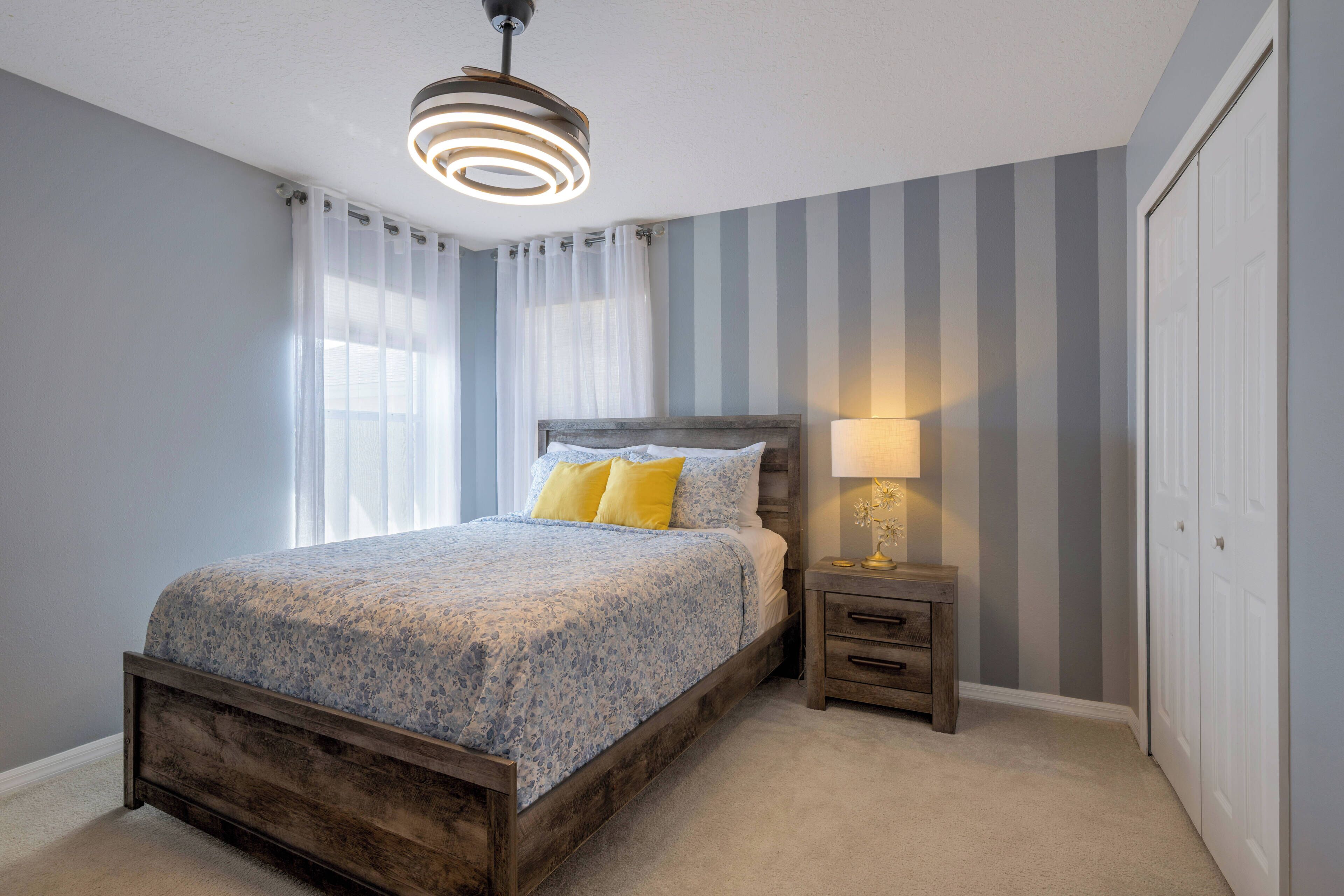 Une chambre à coucher avec un lit en bois, une table de chevet avec une lampe et une armoire.