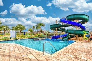 Ein Wasserpark mit Pool, Rutschen und Palmen.