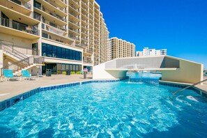 Una piscina con un edificio moderno al fondo.