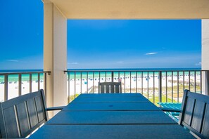 A balcony with a view of a beach, a table, and chairs. - Phoenix Iii 3043 1 Bedroom Condo (Orange Beach)