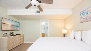 A bedroom with a bed, a dresser, a ceiling fan, a painting, and a lamp. - Phoenix Iii 3043 1 Bedroom Condo (Orange Beach)