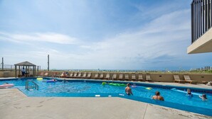 En pool med solstolar och en lusthus.