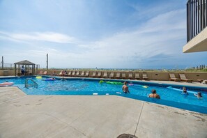 Ein Swimmingpool mit Liegestühlen und einem Pavillon.