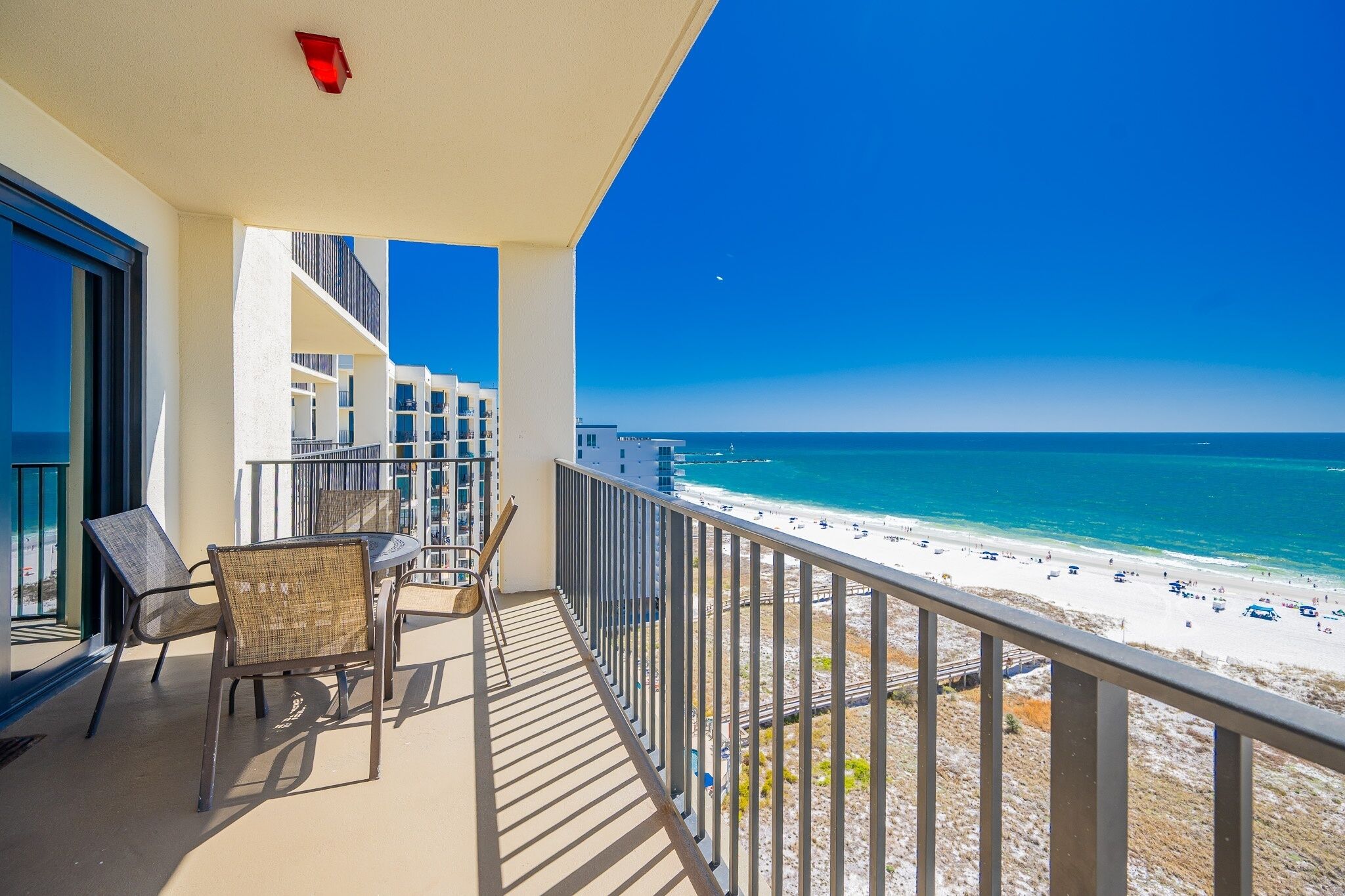 A balcony with a view of the beach and ocean.