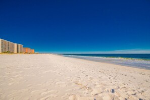 Ein Strand mit weißem Sand und blauem Himmel.